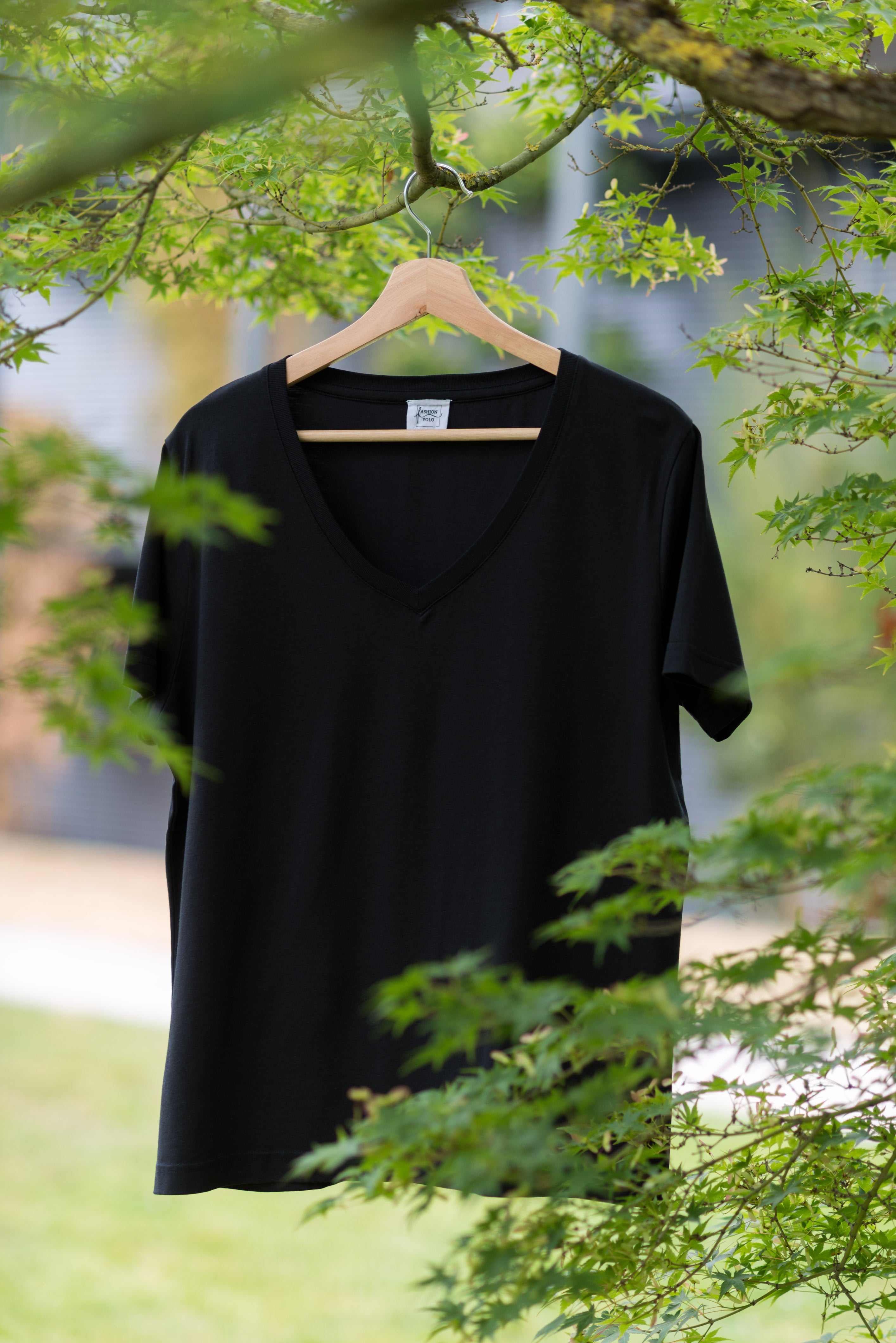 schwarzes lyocell t-shirt rundhals auf einem bügel am baum