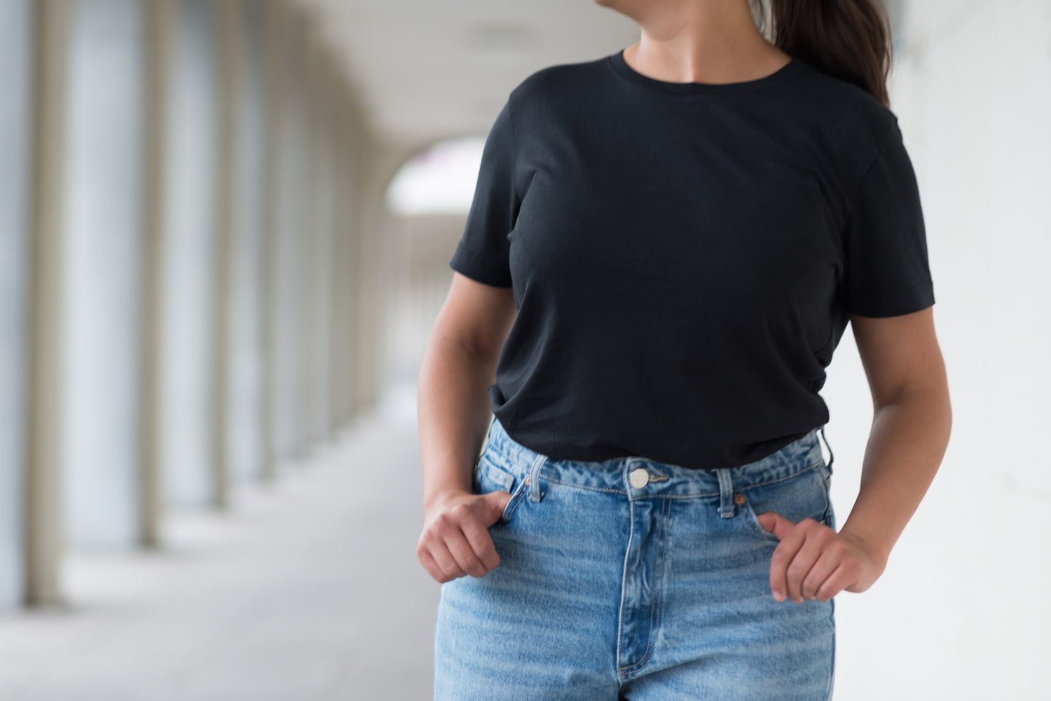 frau steht mit schwarzem lyocell shirt in einem durchgang