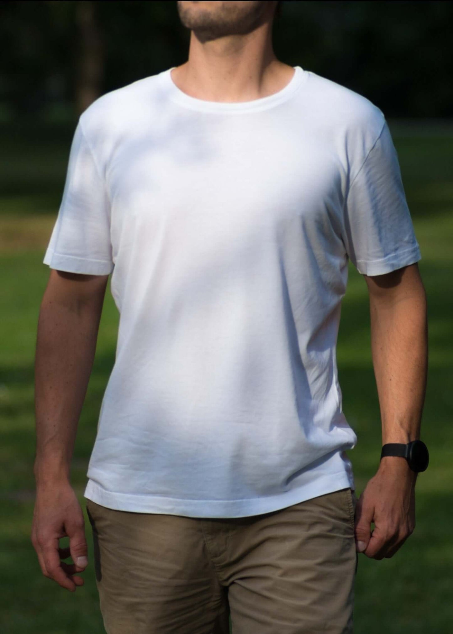 mann steht mit weißem lyocell shirt in einem park