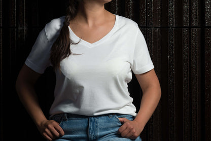 stehende frau mit weißem lyocell shirt mit dunklem hintergrund